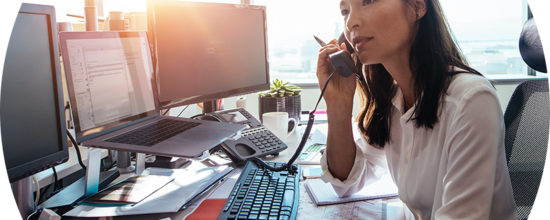 Header image of woman at desk on phone