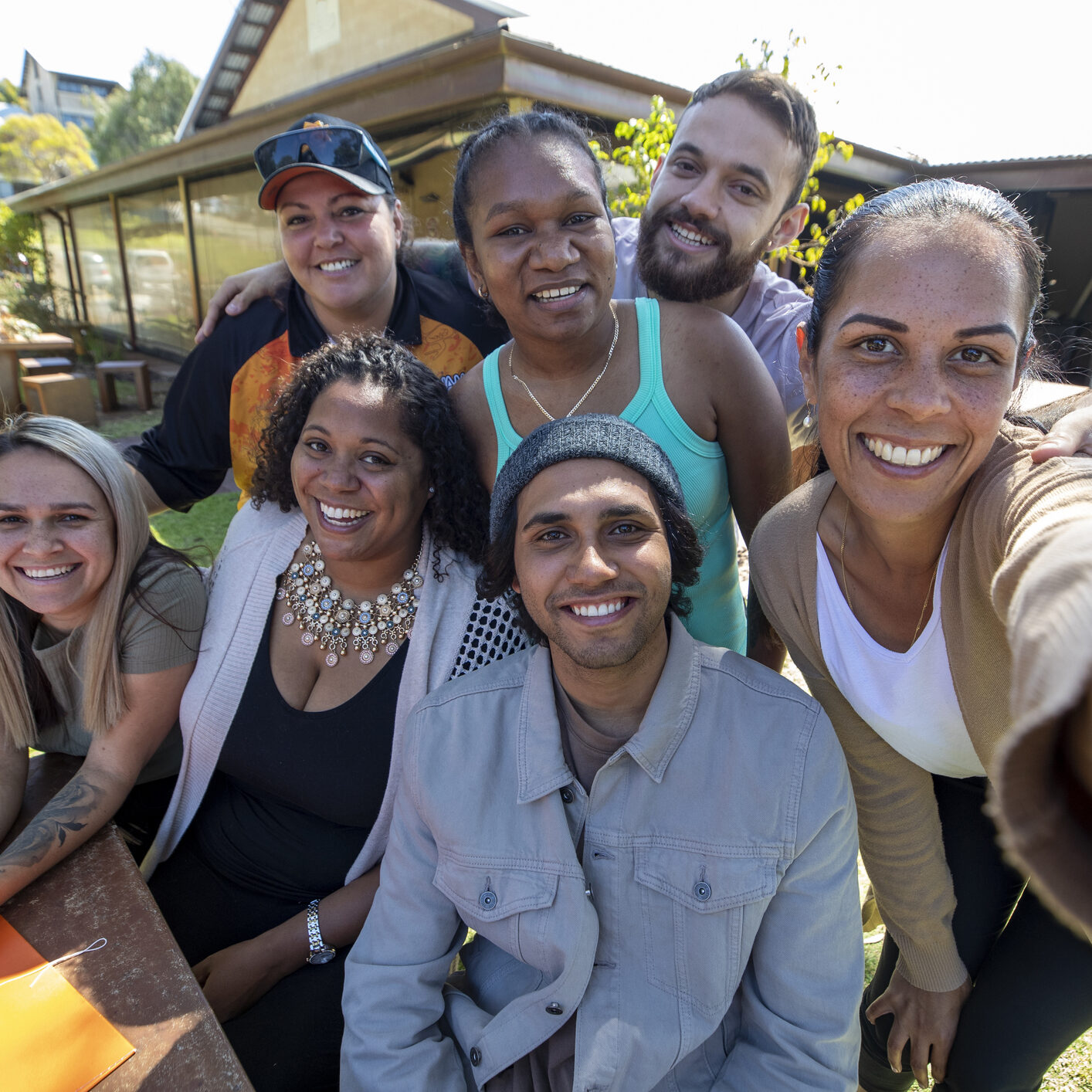 Young aboriginal students and their tutor taking a selfie together outdoors in Australia.
